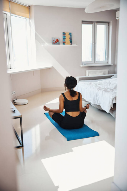 Giovane donna sportiva che pratica yoga a casa - Foto, immagini