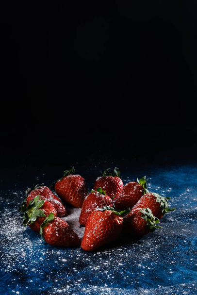 A vertical shot of delicious strawberries with sugar and powder - 写真・画像
