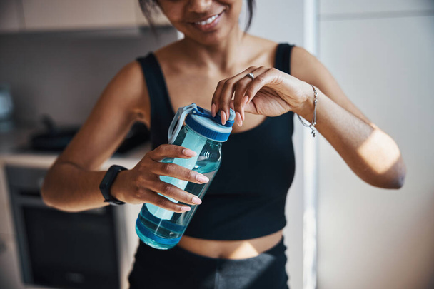 Спортивная молодая женщина с бутылкой воды - Фото, изображение