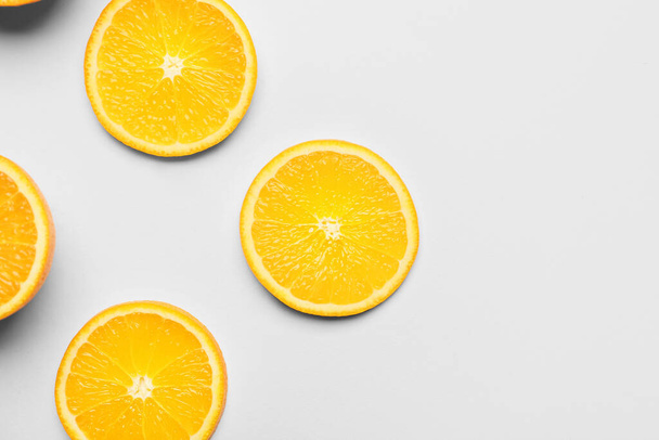 Friss narancssárga gyümölcsök darabjai fehér alapon - Fotó, kép