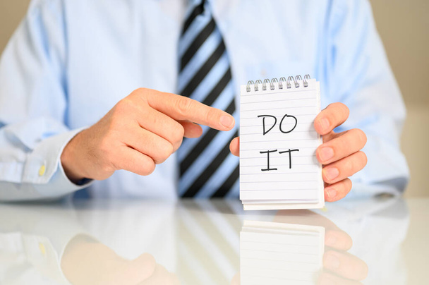 A businessman pointing on a notebook with a catchphrase "Do it" - Fotografie, Obrázek