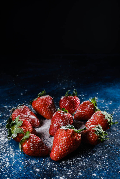 A vertical shot of delicious strawberries with sugar and powder - Foto, Bild
