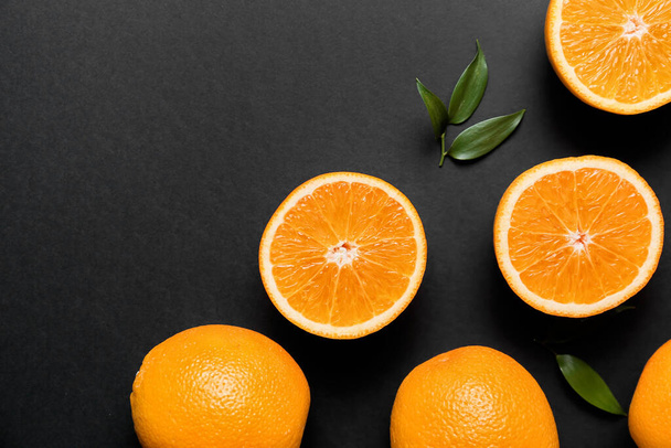 Čerstvé pomeranče se zelenými listy na tmavém pozadí - Fotografie, Obrázek