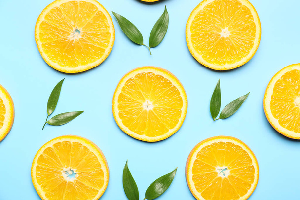 Scheiben frischer Orangen mit grünen Blättern auf farbigem Hintergrund - Foto, Bild