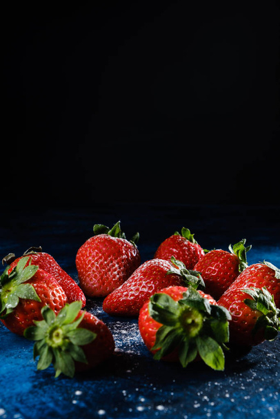 A vertical shot of delicious strawberries with sugar and powder - 写真・画像