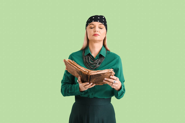 Žena věštkyně s grimoire na barevném pozadí - Fotografie, Obrázek