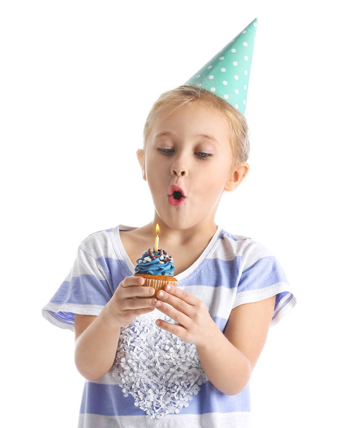 Cute little girl blowing out candle on birthday cupcake against white background - Valokuva, kuva
