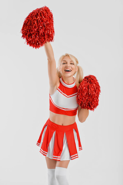 Mooie cheerleader op lichte achtergrond - Foto, afbeelding