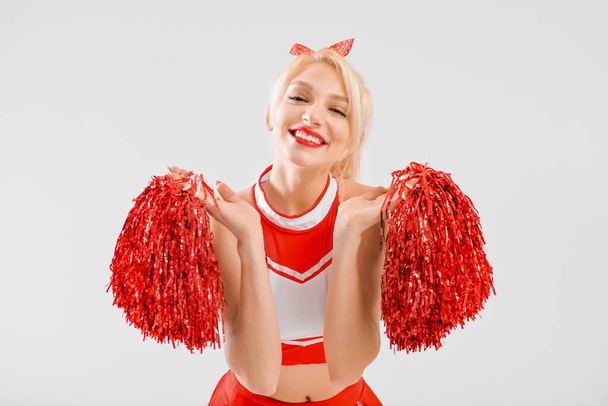 Beautiful cheerleader on light background - Photo, Image