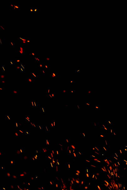 Siyah arkaplanda kıvılcımlar saçan bir ateş alevi - Fotoğraf, Görsel