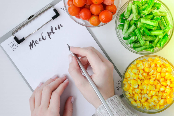 Meal plan. Three Bowls of frozen vegetables food of yellow corn, green beans, red tomatoes. Colors of traffic light. Harvest Food preservation for winter. Copy space - Photo, Image