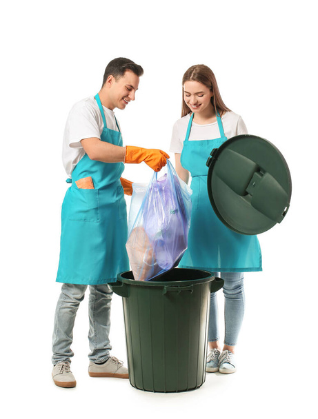 Οι καθαριστές βάζουν σκουπίδια σε κάδο απορριμμάτων σε λευκό φόντο - Φωτογραφία, εικόνα