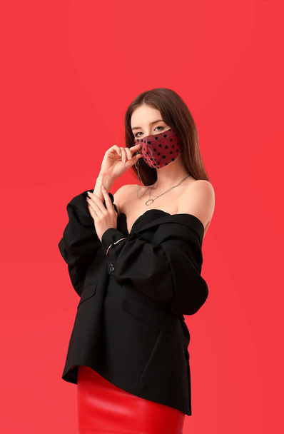 Mulher nova na moda usando máscara no fundo de cor - Foto, Imagem