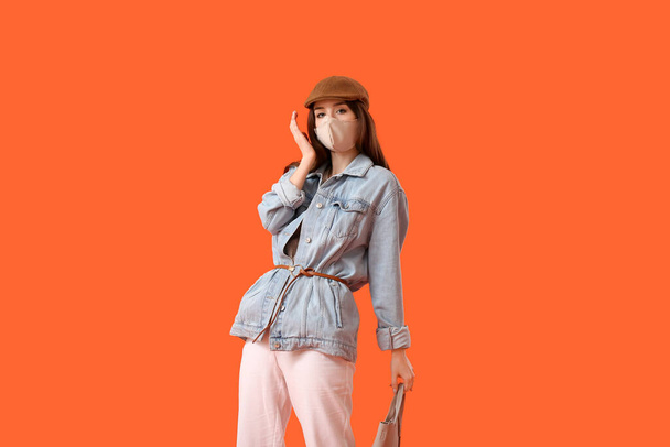 Fashionable young woman wearing mask on color background - Foto, Imagem