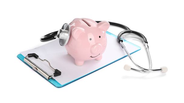 Piggy bank, stethoscope and clipboard on white background - Foto, afbeelding