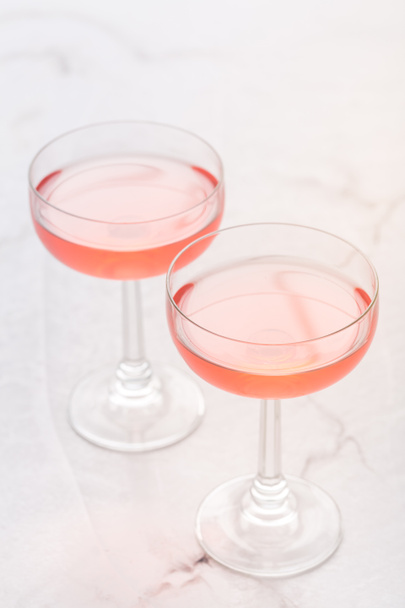Due bicchieri di vino rosa rosa su sfondo di marmo bianco. - Foto, immagini