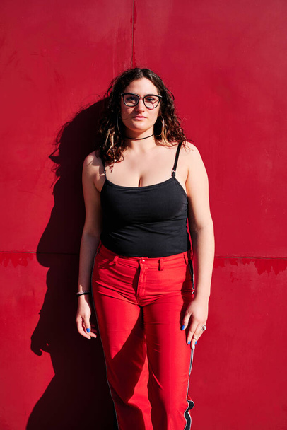 young curvy woman with glasses with a red background - Φωτογραφία, εικόνα