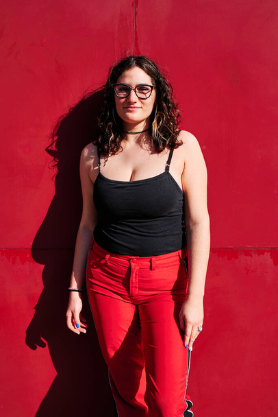 junge kurvige Frau mit Brille mit rotem Hintergrund - Foto, Bild