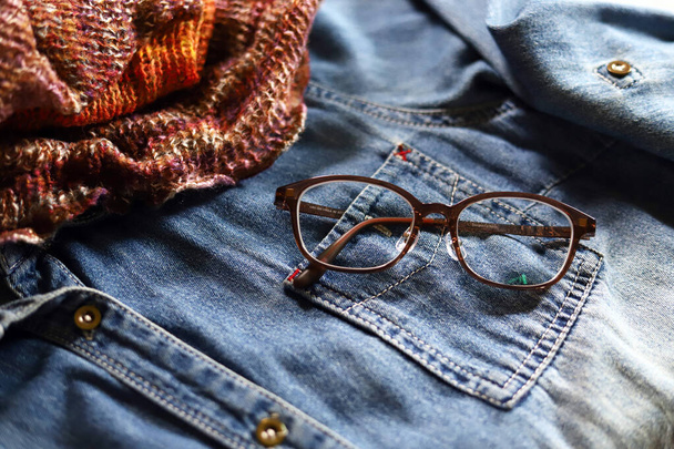 Camicia in denim, snood in maglia e occhiali da vista, moda outfit autunno - Foto, immagini