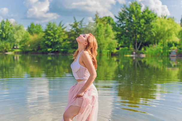 Free relaxed Woman Enjoying Nature. Beauty Girl Outdoor. Freedom concept. Beauty lady with red hair over Sky and Son. Enjoying at the meadow - Fotoğraf, Görsel