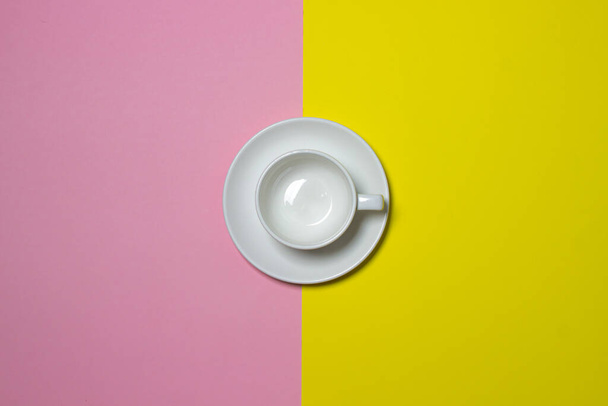 White cup on a geometric background. Empty cup and saucer on a background. white dishes - Fotó, kép
