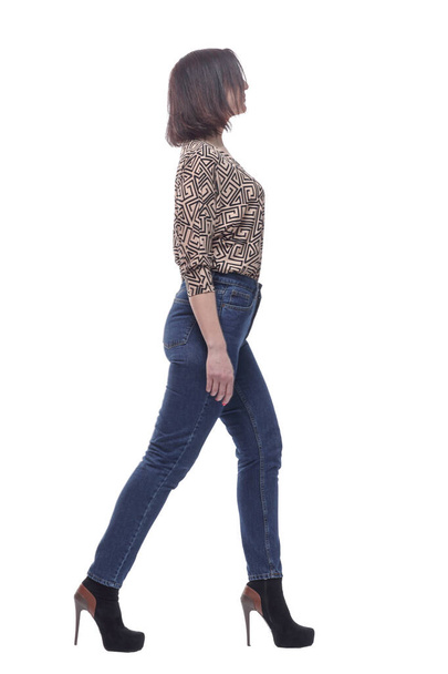 attractive young woman in jeans striding forward. - Фото, изображение