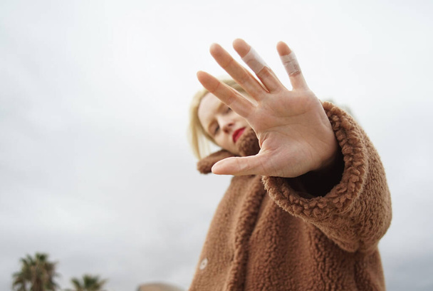 Outdoor portrait of young woman covering with hands her face. - Fotoğraf, Görsel