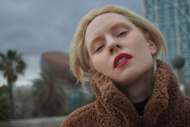 Outdoor headshot portrait of young woman with blonde hair. - Fotó, kép