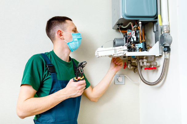Plumber attaches Trying To Fix the Problem with the Residential Heating Equipment. Repair of a gas boiler - Фото, зображення