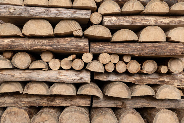 Detail of a woodpile, mostly made of halved tree trunks, stacked alternately lengthways and crossways - Foto, immagini