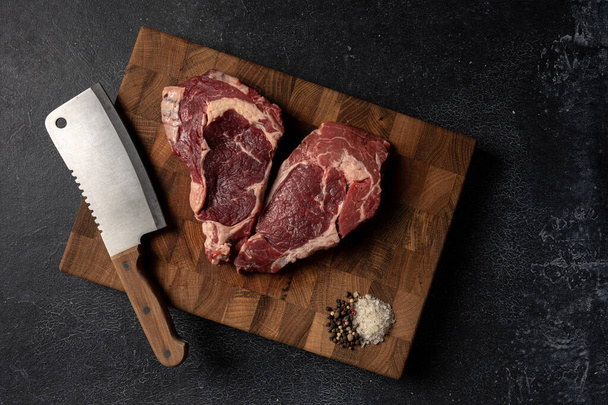 Raw marbled beef steak on a wooden cutting board - Фото, изображение