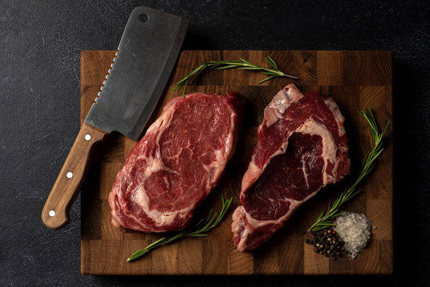 Raw marbled beef steak on a wooden cutting board - Zdjęcie, obraz