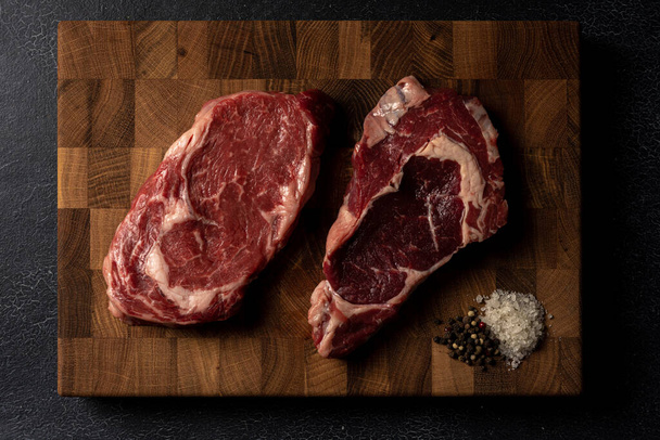 Raw marbled beef steak on a wooden cutting board - Foto, imagen