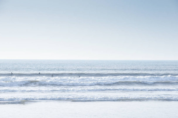 Groupe de personnes surfent et attrapent des vagues dans l'océan - Photo, image