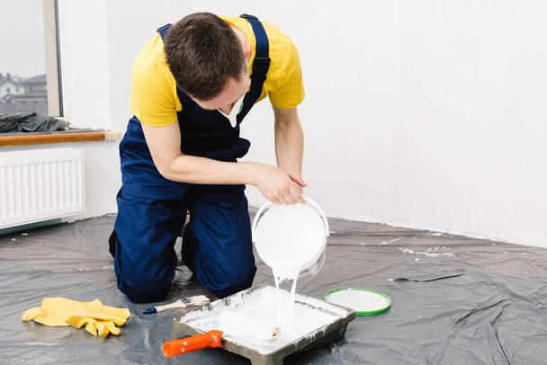 the man paints the walls and the ceiling in white color Painting and repair of the room. - Fotoğraf, Görsel