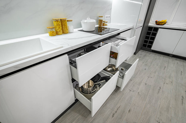 Luksusowe białe i czarne nowoczesne wnętrze kuchni, wyciągnięte szuflady - Zdjęcie, obraz