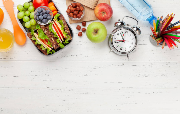 Healthy school lunch box with sandwich and fresh vegetables, water bottle, nuts and fruits. Top view flat lay with copy space - Photo, Image