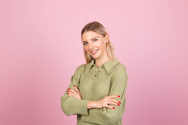 Pretty european woman in casual knitted sweater on pink background with crossed hands smile to camera isolated copy space - Photo, Image