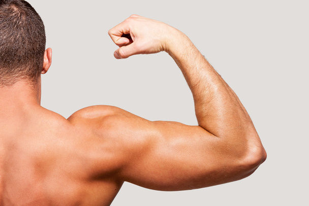 Muscular man showing his bicep - Photo, image