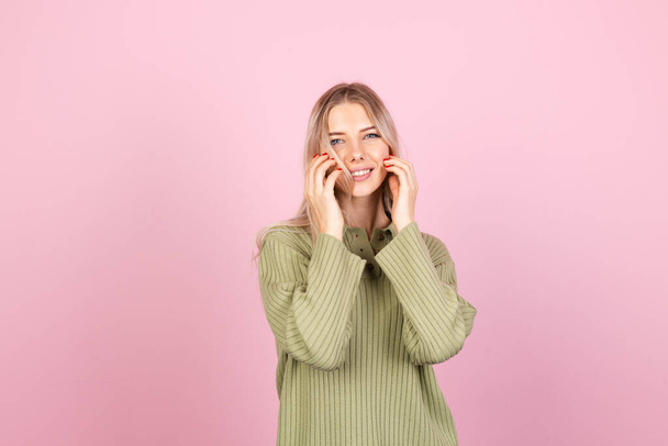 Pretty european woman in casual sweater on pink background cute smiling happy positive dancing moving - 写真・画像