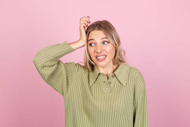 Pretty european woman in casual sweater on pink background preoccupied put hand on head look aside copy space - Photo, Image