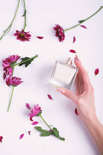 Жіноча рука з парфумами та квітами
 - Фото, зображення