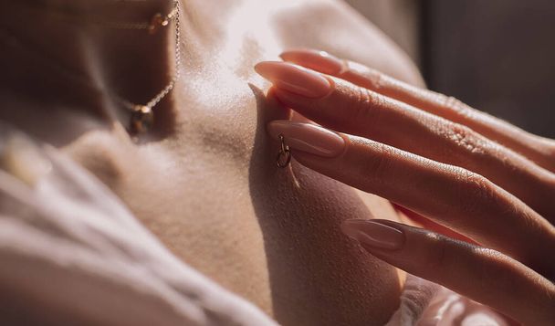 κοντινό γυναικείο σώμα, δάχτυλα αγγίζουν κλείδα - Φωτογραφία, εικόνα