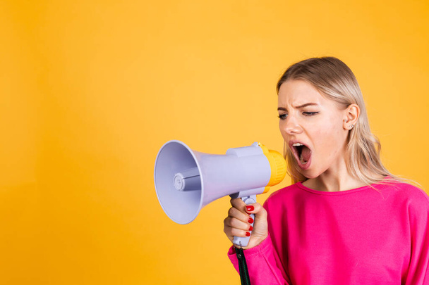 Pretty european kobieta w różowej bluzce na żółtym tle zły poważne krzyki w megafon poprosić o uwagę - Zdjęcie, obraz