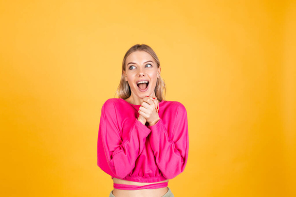 Mooie europese vrouw in roze blouse op gele achtergrond gelukkig geschokt verbaasd verbaasd open mond - Foto, afbeelding