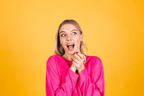Hübsche europäische Frau in rosa Bluse auf gelbem Hintergrund glücklich schockiert überrascht offenen Mund - Foto, Bild