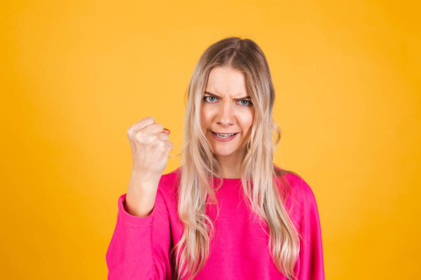 Mulher muito europeia em blusa rosa no fundo amarelo gritos com raiva, censura acusa-lo, aponta diretamente para a câmera, culpa você - Foto, Imagem