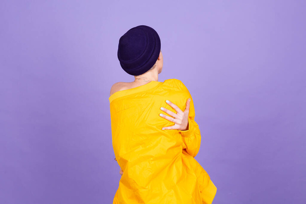 Stylish european woman on purple background self care hugging herself with smile and closed eyes - Foto, afbeelding