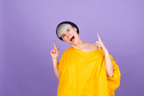Elegante mujer europea en púrpura punto de fondo a la cámara con la cara feliz - Foto, Imagen