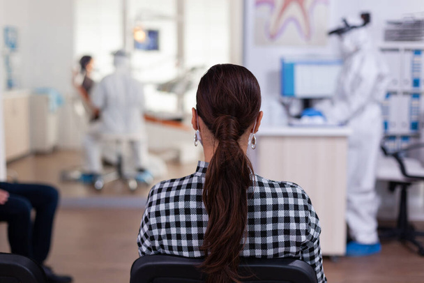 Γυναίκα ασθενής στο οδοντιατρικό γραφείο περιμένει για τη διάγνωση - Φωτογραφία, εικόνα